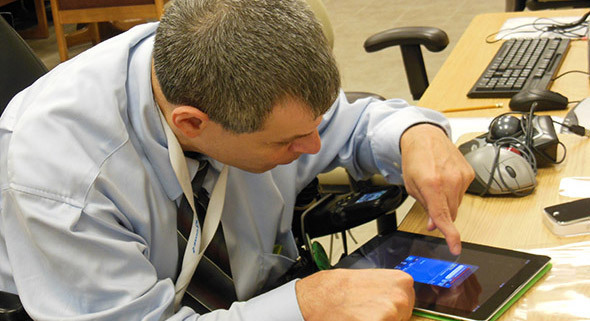 Photo of person w/ disability utilizing assistive technology.