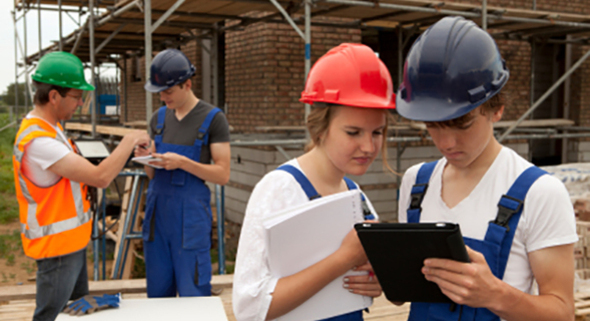 Photo of 3 youths(2 girls & 1 boy) leaning/working at a construction site with a professional.